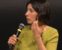 a woman talking into a microphone