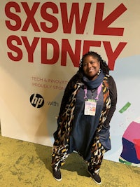 a black woman smiling with a scarf on her head