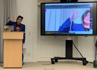 a woman giving a presentation in front of a screen